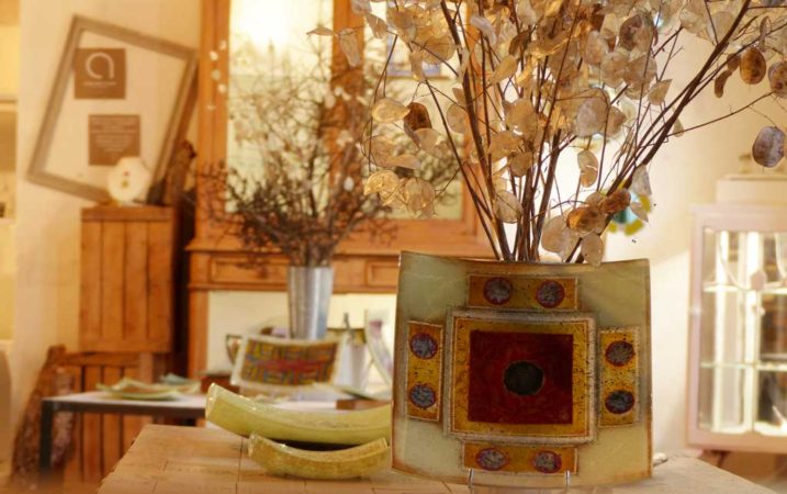 vue de plats en verre avec au fond des bouquets de fleurs séchées